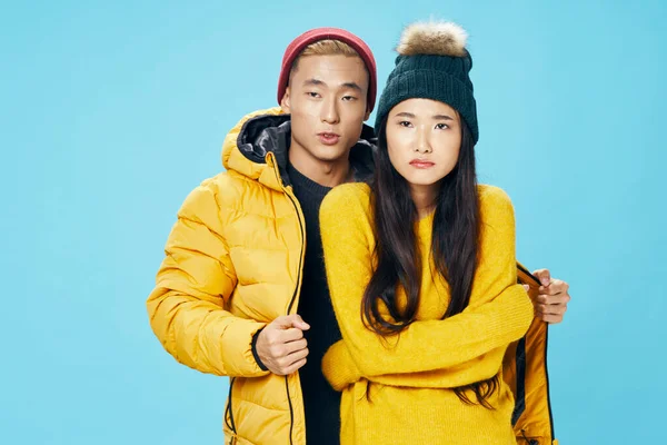 Homem de aparência asiática abraça uma mulher em uma jaqueta amarela — Fotografia de Stock