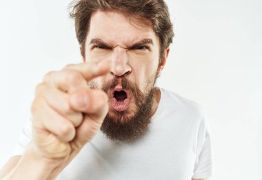 Beyaz tişörtlü genç bir adam elleriyle hareket eder. Duyguları gerilir.