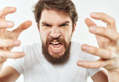 Beyaz tişörtlü genç bir adam elleriyle hareket eder. Duyguları gerilir.