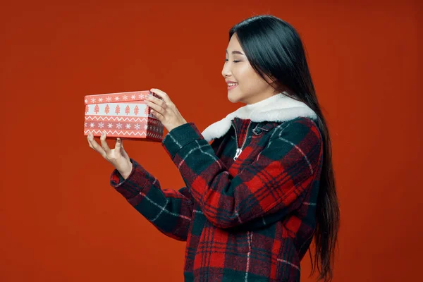 Жінка з подарунковою коробкою в яскравому одязі на фоні . — стокове фото