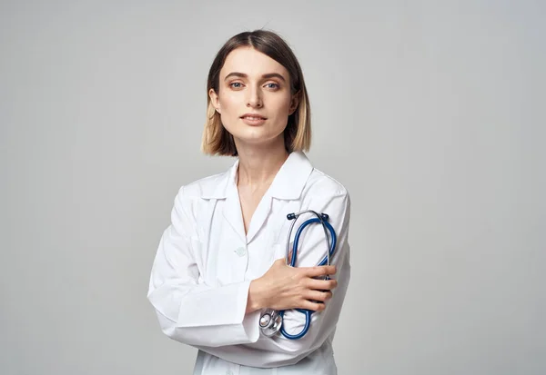 Mulher de casaco branco médico e estetoscópio na mão — Fotografia de Stock