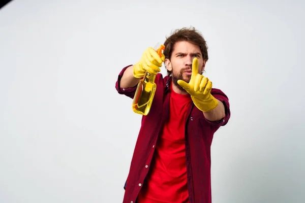 Man with detergent professional cleaning homework light background — Stock Photo, Image