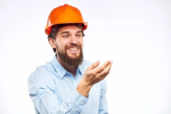A man in a working uniform orange hard hat gestures with his hands emotions Construction engineer Professional — Stock Photo, Image
