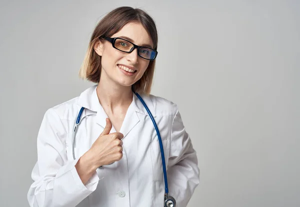 Donna medico con stetoscopio gesticolando con le mani emozioni occhiali modello — Foto Stock