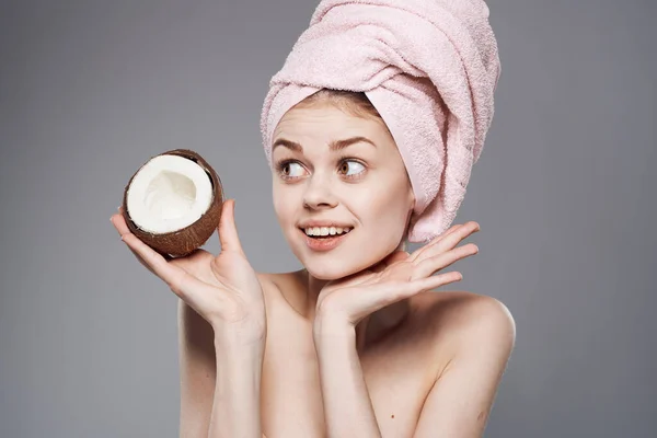 Wanita emosional dengan handuk merah muda di kepalanya kelapa di tangan buah-buahan tropis kulit bersih — Stok Foto
