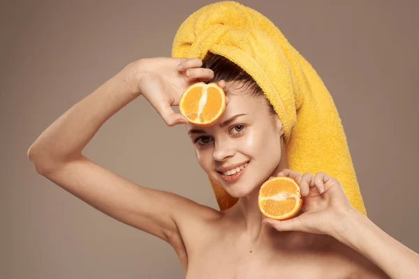 Woman with a towel on her head bared shoulders citrus fruits in hands skin care — Stock Photo, Image