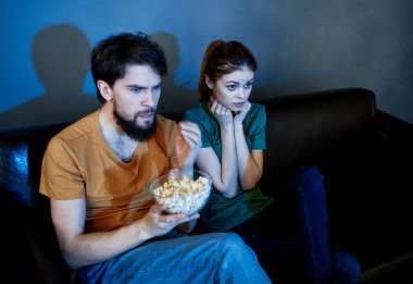 Akşamları kanepede televizyon seyrediyor ve kadın aile dostları olan bir adam.