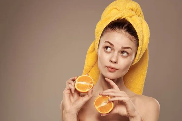 Wanita dengan handuk di kepalanya bergerigi jeruk bahu buah di tangan perawatan kulit — Stok Foto