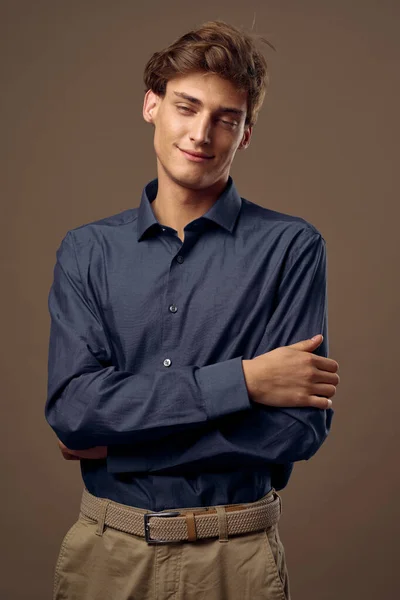 Young guy in a shirt and trousers hugging himself with his hands and smiling — Stock Photo, Image