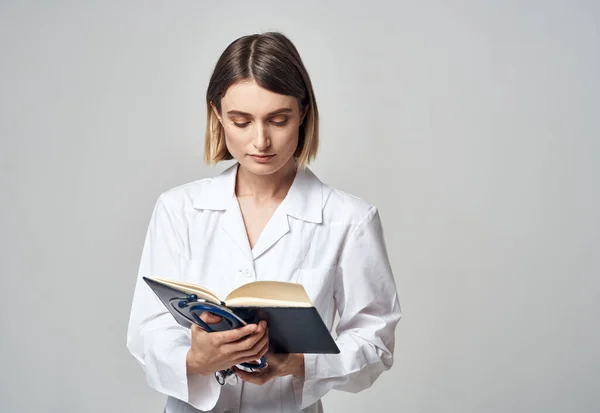 Femme médecin avec stéthoscope et des documents de robe médicale dans les mains — Photo