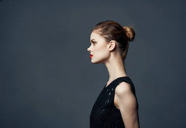 Side view of beautiful woman in black dress with hairstyle