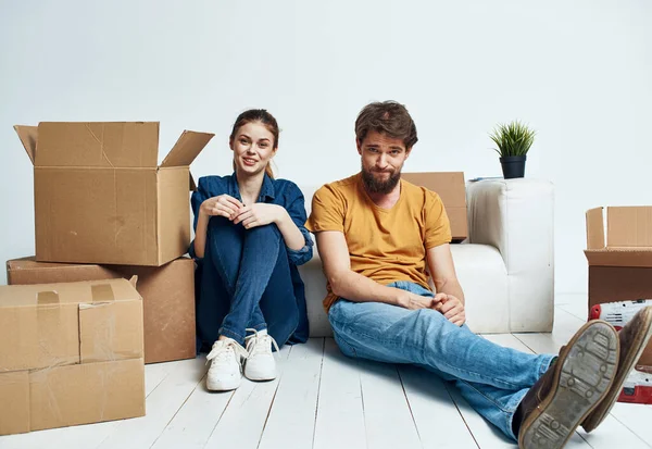 En man och en kvinna med lådor rör sig. En lägenhet renoveras av en familj. — Stockfoto