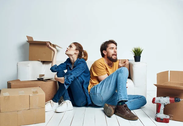 Stěhování renovace šťastný muž a žena na podlaze v novém bytě s krabicemi — Stock fotografie