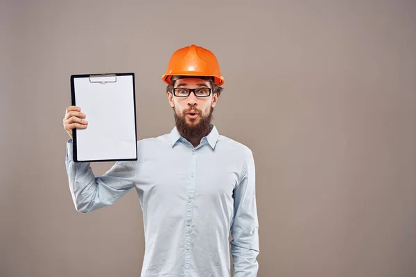 Homem emocional vestindo chapéu laranja duro em documentos da indústria — Fotografia de Stock