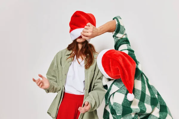 Un uomo guarda sotto il cappello di una donna vacanza divertente Capodanno — Foto Stock