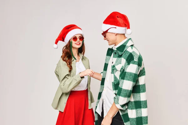 Junges Paar mit Sonnenbrille und Weihnachtsmannhut umarmt Freundschaftsurlaub — Stockfoto