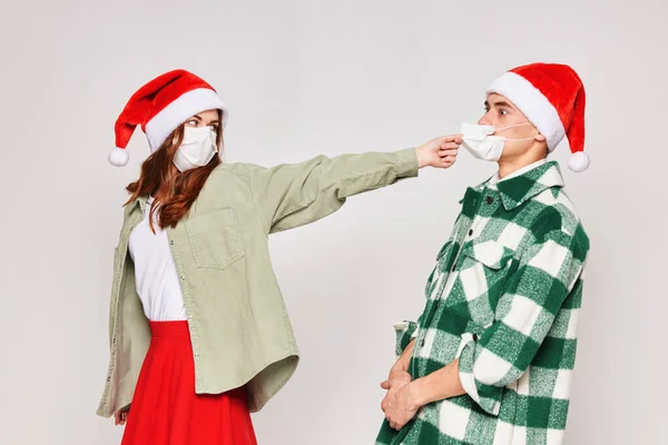 Жінка знімає чоловік медична маска різдвяна студія сірий фон — стокове фото