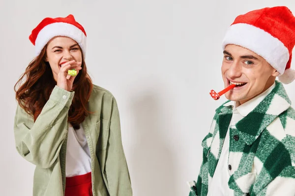Веселий чоловік і жінка святкові труби Різдвяні новорічні капелюхи веселі — стокове фото