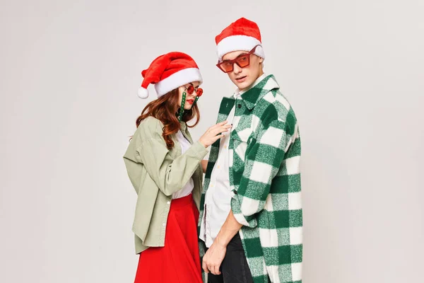 Молода пара стоїть поруч один з одним обіймає новорічне свято — стокове фото