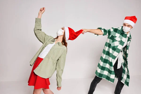 Молода пара Різдвяні капелюхи святкові емоції весело разом — стокове фото