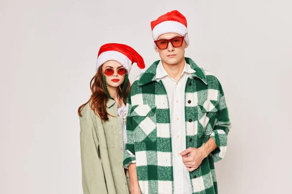 Чоловік і жінка стоять пліч-о-пліч в сонцезахисних окулярах Різдвяні свята Новорічні капелюхи дружба — стокове фото