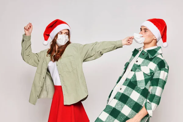 Erkek ve kadın tıbbi maskeler takıyor. Yeni yıl stüdyo Noel 'i. — Stok fotoğraf