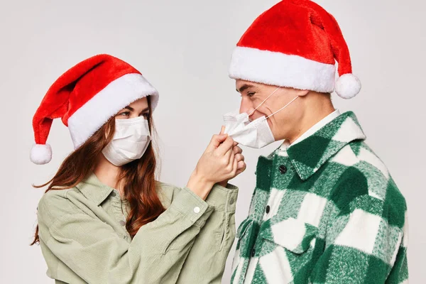 Жінка одягає чоловіка захистом медичної маски новорічне свято разом — стокове фото