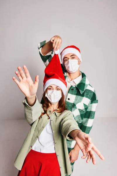 Мила молода пара зимових різдвяних медичних масок святкують новий рік разом — стокове фото