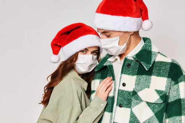 Чоловік і жінка в захисті медичних масок обіймає разом дружбу новорічне свято — стокове фото