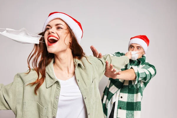 Veselá žena a muž lékařské masky vánoční prázdniny zábavné emoce — Stock fotografie