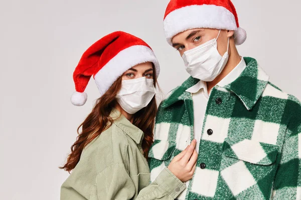 Молода пара в медичних масках Різдвяні капелюхи свято крупним планом — стокове фото