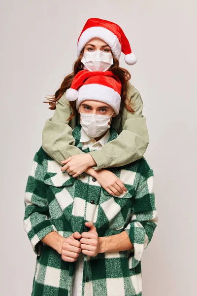 Молода пара в медичних масках Різдвяні канікули обійми — стокове фото