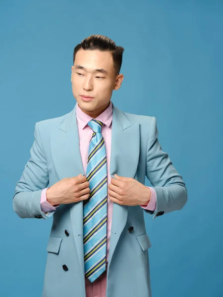 Biznes człowiek w garniturze na niebieskim tle prostuje swoją kurtkę przycięty widok model zbliżenie — Zdjęcie stockowe