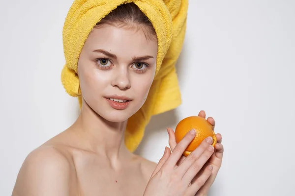 Pretty woman you yellow towel on head oranges citrus clean skin light background — Stock Photo, Image