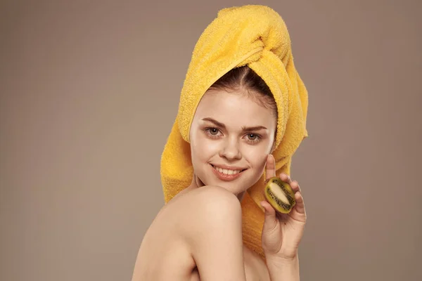 Bella donna con spalle nude asciugamano sulla testa pelle pulita kiwi vitamine fresche — Foto Stock
