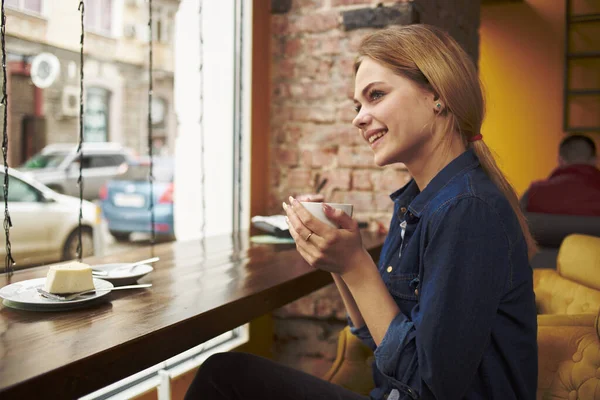 Mulher bonita sentada em uma mesa de café com uma xícara de café da manhã estilo de vida — Fotografia de Stock
