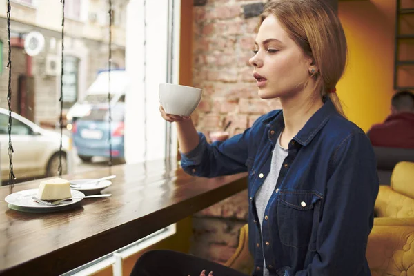 Mulher bonita sentada em uma mesa de café com uma xícara de café da manhã estilo de vida — Fotografia de Stock