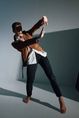 Adam ellerini kapalı kapılar ardında ışıktan koruyor.