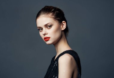 Gri arka planda siyah elbiseli kadın makyaj modeli görünümünü kırpmış.