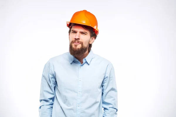 Homem em laranja chapéu duro indústria engenheiro trabalho profissional luz fundo — Fotografia de Stock