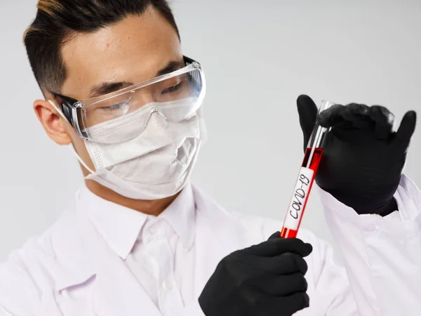 Чоловічий лабораторний асистент в чорних рукавичках аналіз крові на наявність дослідницьких вірусів — стокове фото