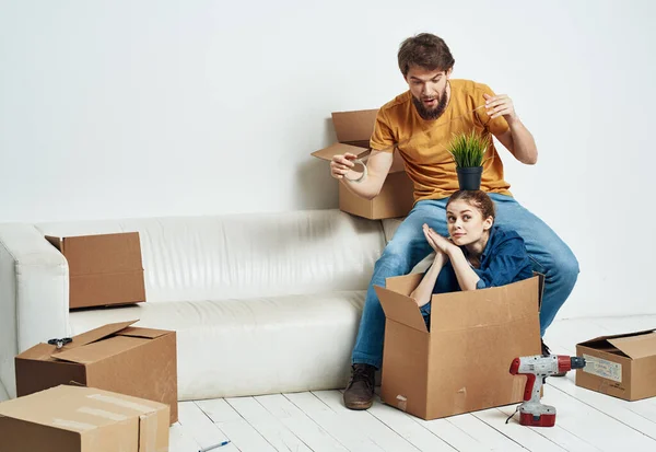 Acogida de la casa pareja mudándose a un nuevo apartamento cajas con cosas — Foto de Stock