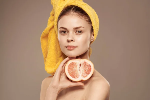 Beautiful woman with a towel on her head bared shoulders grapefruit Skin care — Stock Photo, Image