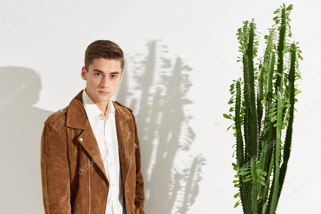 Portrait of a man in a brown jacket near a cactus flower