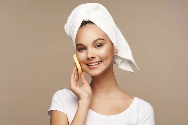 Žena s houbou v rukou čistý kožní ručník na hlavě pro lázeňské léčby — Stock fotografie