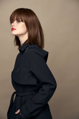 Güzel esmer ceketli, kemer takan çekici gülüşlü izole bir arka planda eğlenen