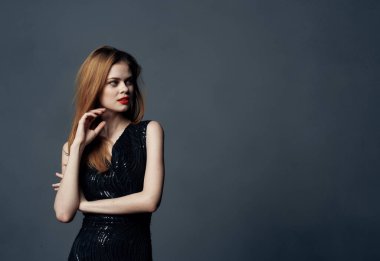 Siyah elbiseli güzel bir kadın. Kızıl saçlı. Arka plan. Uzay Modelini kopyala.