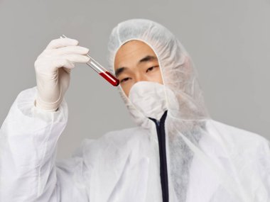 Adam laboratuvar kıyafetleri araştırması aşıyı analiz ediyor.