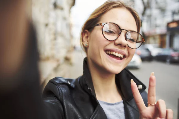 Portret szczęśliwej kobiety w okularach i skórzanej kurtce na zewnątrz uśmiechnięty model — Zdjęcie stockowe