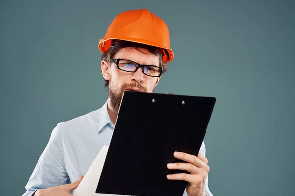 Homem trabalhador com documentos em mãos usando óculos laranja capacete profissional de segurança — Fotografia de Stock